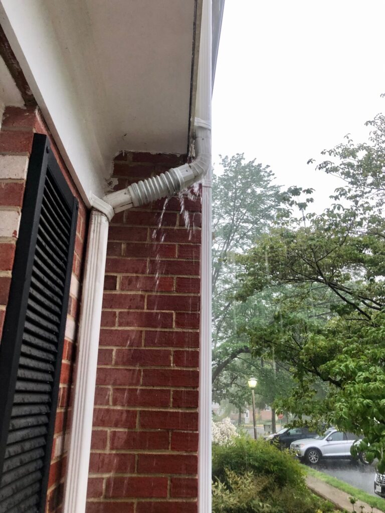 Rain overflowing gutters and downspout