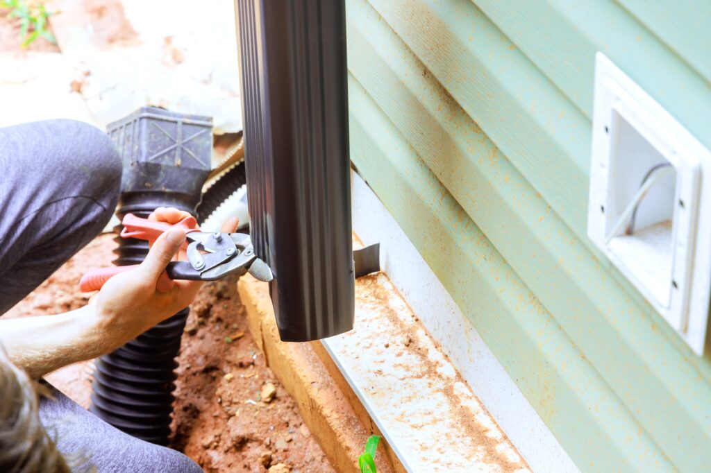 This handyman is assembling gutter channels that have been attached to a roof with installation